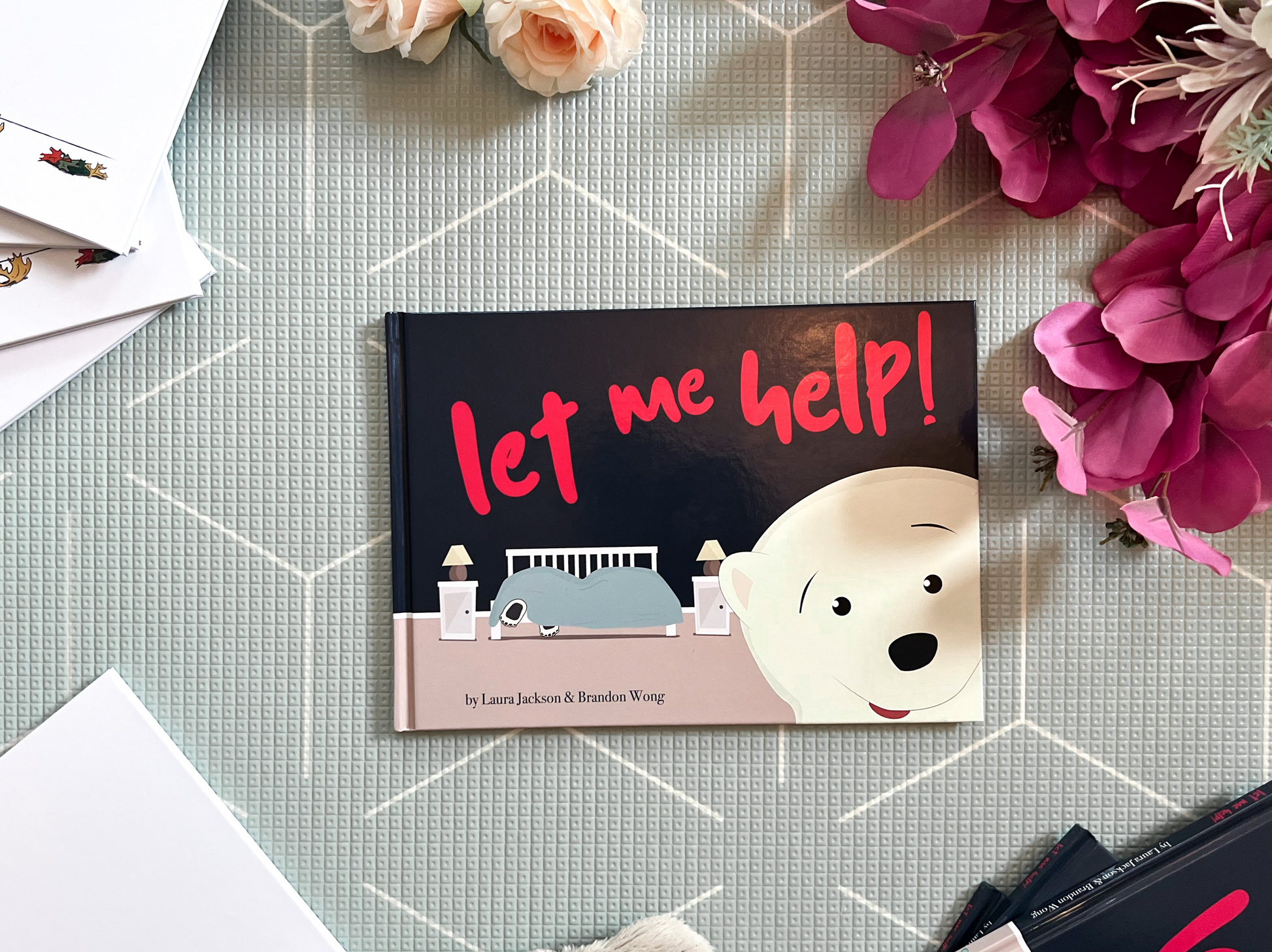 Cover of Let Me Help! book surrounded by flowers and other books